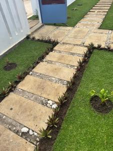 a garden with a stone walkway next to a house at Casa de Férias Chocas Mar in Mossuril