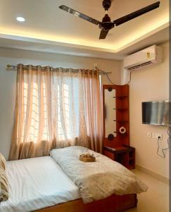 a bedroom with a bed with a ceiling fan and a window at Hotel nightout in Calangute