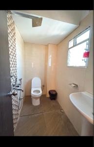 a bathroom with a toilet and a sink and a window at Hotel nightout in Calangute