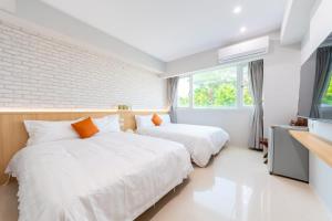 台南市にある暮樂行旅 -改裝新登場-預訂後務必連絡民宿再一次確認のテレビと窓のある部屋にベッドが2つあります