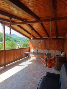 a porch with a hammock hanging from a wooden roof at Casa Claudia in Slănic-Moldova