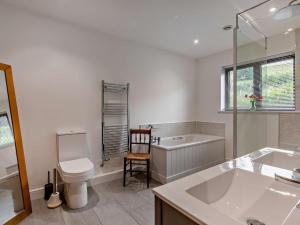 a bathroom with a tub and a toilet and a sink at 5 Bed in Dulverton 87003 in Morebath +23 photos