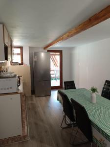 a kitchen with a table with chairs and a refrigerator at Casa Claudia in Slănic-Moldova