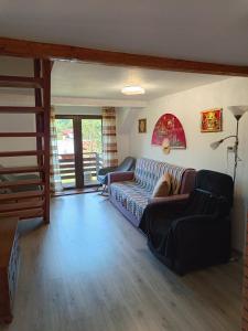 a living room with a couch and a staircase at Casa Claudia in Slănic-Moldova