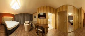 a bedroom with a bed and a desk with a television at Hotel-Restaurant Schweinberger in Stetten
