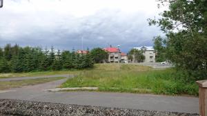 un champ d'herbe avec des maisons en arrière-plan dans l'établissement Alba Guesthouse, à Reykjavik