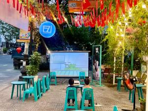 a couple of children sitting on chairs in front of a screen at Thai Binh Motel in Danang