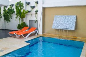a swimming pool with two chairs and a water fountain at Hotel Or Cartagena in Cartagena de Indias