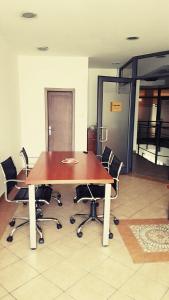 een houten tafel met stoelen in een lege kamer bij Apartment The Royal Pg in Podgorica