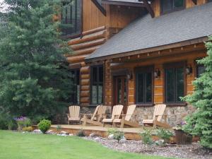 a group of chairs sitting on a deck in front of a log cabin at Cozy Lodge Suite Rental with Mountain Views in Silver Bow County, Montana in Divide