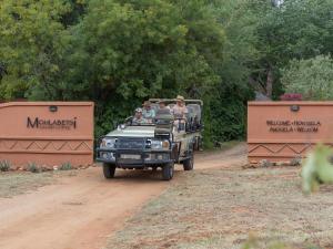 a group of people riding in a jeep on a dirt road at Mohlabetsi Safari Lodge in Hoedspruit