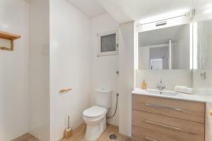 a white bathroom with a toilet and a sink at La Bahia in Santa Cruz de Tenerife +16 photos