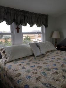 - un lit avec des oreillers dans une chambre avec une fenêtre dans l'établissement Bayfront Cottage Rental with a Private Beach on Virginia's Eastern Shore, à Onancock