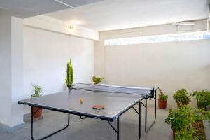 a ping pong table in a room with plants at Juniper6 BR Mountain View Villa Cook Staff Deck in Parwanoo