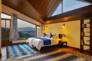 a bedroom with a bed and a large window at Juniper6 BR Mountain View Villa Cook Staff Deck in Parwanoo