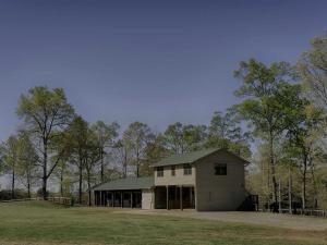 GowensvilleにあるAmazing Cabin Rental on 22-Acre Horse Farm near Tryon International Equestrian Center, South Carolinaの野原の緑屋根白屋