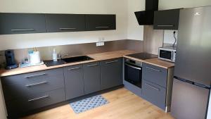 a small kitchen with gray cabinets and appliances at Maison l'Echappée Belle Pyrénées in Vicdessos