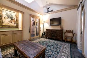 a living room with a table and a tv at Breathtaking Cottage Rental on Castle Grounds Overlooking Lake George in Bolton Landing +24 photos