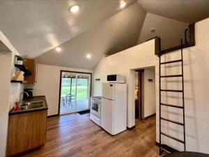 a kitchen with a white refrigerator and a ladder at Black Hills Glamping Cabin, Perfect for an Outdoor Adventure in Hill City
