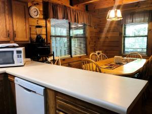 une cuisine avec un comptoir blanc et une table dans l'établissement Stunning Pet-Friendly Cabin Rental near Charleston, West Virginia, à Hico 5 autres photos