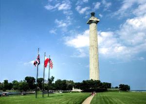 Ein hoher Turm mit amerikanischen Flaggen auf einem Feld in der Unterkunft Spacious Vacation Cottage Rental near the Waterfront in Beautiful Put-in-Bay, Ohio in Put-in-Bay