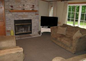 ein Wohnzimmer mit Couch und Kamin in der Unterkunft Spacious Vacation Cottage Rental near the Waterfront in Beautiful Put-in-Bay, Ohio in Put-in-Bay