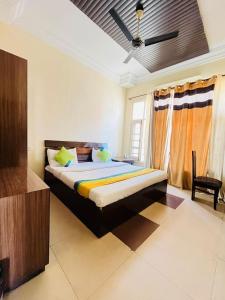 a bedroom with a bed and a ceiling fan at Hotel kingston in Zirakpur