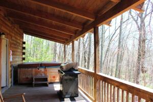 a screened in porch of a cabin with a grill at Spectacular Cabin Rental for Large Groups near New River in West Virginia in Hico
