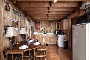 a kitchen with a table with chairs and a refrigerator at Rustic-Modern Chalet w/ Fire Pit, Deck & Views in Slanesville, WV in Slanesville