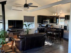 a living room with a couch and a kitchen at The Ultimate Romantic Getaway: Charming Cabin with a Hot Tub in Wimberley, Texas in Woodcreek