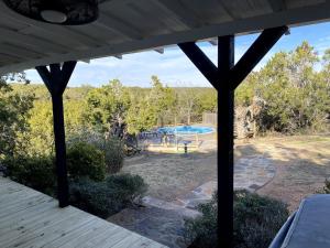 a view of a backyard with a swimming pool at The Ultimate Romantic Getaway: Charming Cabin with a Hot Tub in Wimberley, Texas in Woodcreek
