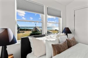 a bedroom with a bed and a large window at Peaceful Oceanfront Villa in Bourne, Massachusetts in Patuisset