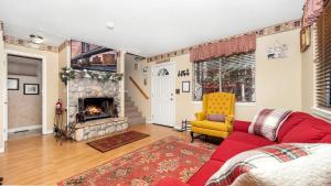 ein Wohnzimmer mit einem roten Sofa und einem Kamin in der Unterkunft Charming Cabin for Winter and Water Sports Fans Near Big Bear Lake, California in Arrowbear Lake + 22 Fotos