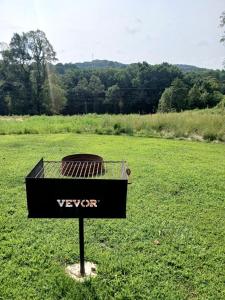a grill in the middle of a grass field at Fantastic Secluded Tented Cabin with Fire Pit in Logan, Ohio in Logan