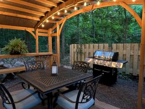 eine Terrasse mit einem Tisch, Stühlen und einem Grill in der Unterkunft Elegant, Vintage Conestoga Covered Wagon Getaway in Denver, Pennsylvania in Denver