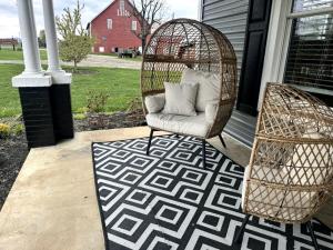un portico con una sedia in rattan e un tappeto di Cute Cottage on Working Farm for Farmstay Glamping Getaways to Virginia - Perfect for Animal Lovers a Fairview