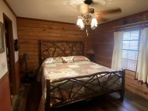 a bedroom with a bed with a wooden wall at Rustic Log Cabin Rental near Chattahoochee National Forest, Georgia in Hiawassee