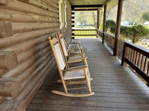three rocking chairs sitting on the porch of a log cabin at Rustic Log Cabin Rental near Chattahoochee National Forest, Georgia in Hiawassee