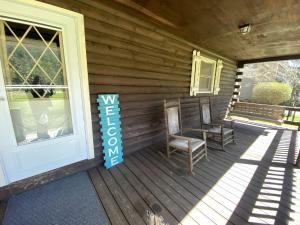 a porch with two chairs and a sign on it at Rustic Log Cabin Rental near Chattahoochee National Forest, Georgia in Hiawassee +22 photos