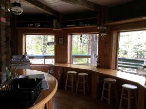 a kitchen with a counter and stools in a cabin at Secluded and Relaxing Luxury Cabin Rental in Adirondack Park in Wells