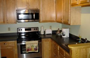 a kitchen with a stove and a microwave at Pre-Civil War Servants' Cottage on Huge Horse and Cattle Farm near Charlottesville, Virginia in Gordonsville