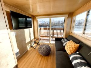 een woonkamer met een bank en een flatscreen-tv bij Amazing Airstream in Grand Junction for Unforgettable Family Glamping Getaways in Colorado in Grand Junction