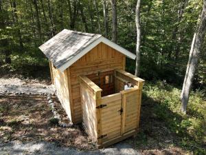 a small wooden dog house with a roof at Secluded Getaway Spot in a Quiet Forest for Camping near Charlottesville, VA in Howardsville