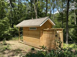 a wooden outhouse in the middle of a forest at Secluded Getaway Spot in a Quiet Forest for Camping near Charlottesville, VA in Howardsville
