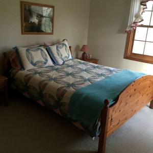 a bedroom with a large bed with a blue blanket at Gorgeous Eco-Friendly Cottage Rental with a Gazebo in Jamaica, Vermont in Jamaica