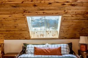 a bedroom with a wooden wall and a window at Charming Vacation Rental in the Heart of South Park near Fairplay, Colorado in Jefferson