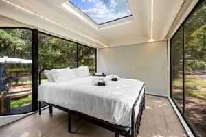 a bedroom with a bed and large windows at Modern Airstream Glamping with Pond Views in Rural South Carolina in Saint Stephen