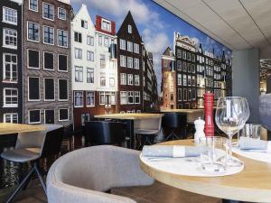 a restaurant with a mural of a city at Mercure Amsterdam City Hotel in Amsterdam
