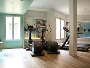 een sportschool met hometrainers en crosstrainers in een kamer bij Mercure Paris Roissy CDG in Roissy-en-France +216 foto's