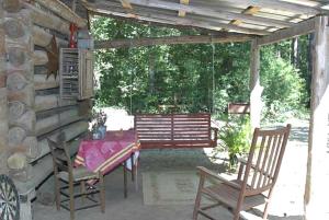 a patio with a table and chairs and a bench at Quaint Four-Person Camping Cabin near Big Ticket Preserve, Texas in Kountze